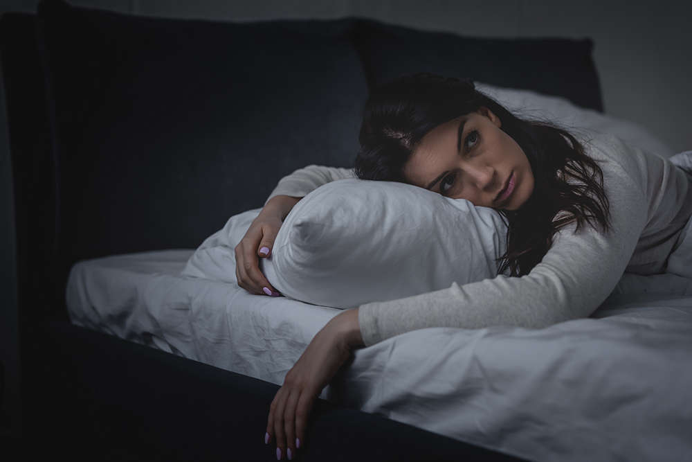 woman-with-insomnia-laying-horizontally-on-bed-sleep-wake-disorders